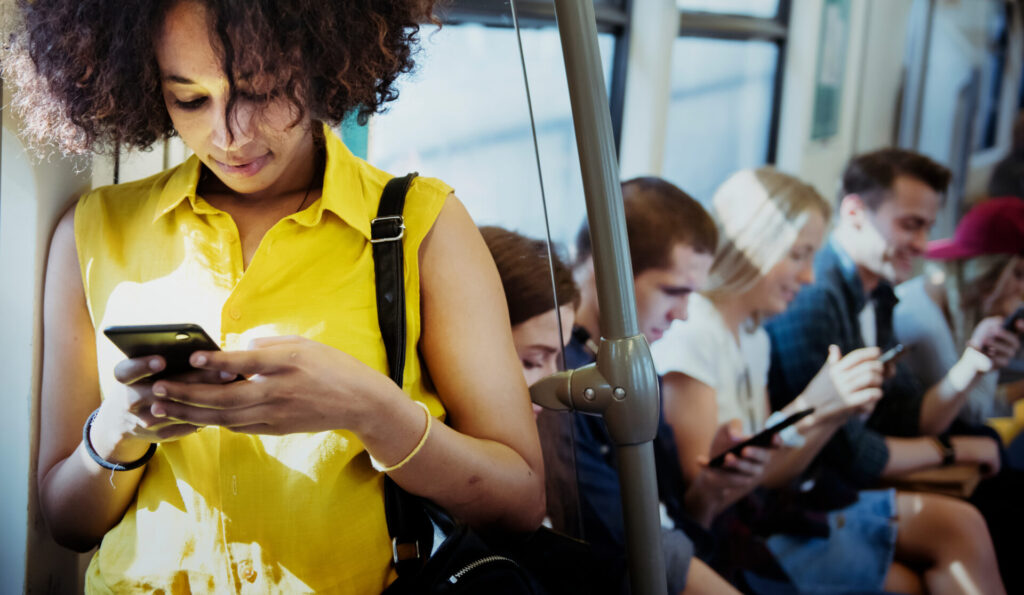 Menschen in der Bahn schauen auf ihre Smartphones